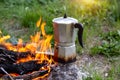 Metal coffee maker on an open fire in nature. Making coffee. Camping in summer Royalty Free Stock Photo