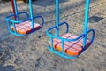 Metal colorful swings with wooden seat on children playground