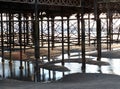 Columns and supports underneath blackpool north pier at low tide reflected in the water on the beach Royalty Free Stock Photo