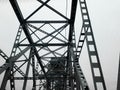 Metal construction of the railway bridge with the rising middle part for the passage of ships.