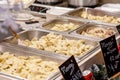 Metal containers full of freshly cooked delicious hot steaming Polish pierogi, restaurant, traditional festive market food