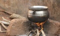 Metal cooking cauldron over wood fire