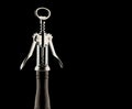 Metal corkscrew on neck of wine bottle isolated on black background Royalty Free Stock Photo