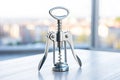 Chrome corkscrew on a white table with city view Royalty Free Stock Photo