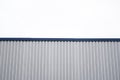 Metal corrugated sheets on a building with a blue metal corners. White aluminium metal corrugated roof or wall sheets Royalty Free Stock Photo