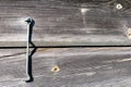 A metal cramp on a wall of moss green boards