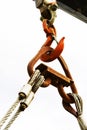 A metal crane hook holds the load on the ropes. Vertical photo. Close-up