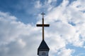 metal cross atop a steeple against a cloudy sky Royalty Free Stock Photo