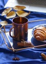 Metal cup of tea on the tray on the blue bed sheet