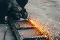 Metal cutting with an electric circular saw. Sparks fly in different directions. Blurred focus Royalty Free Stock Photo