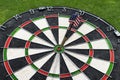 Metal darts have hit the red bullseye on a dart board. Darts Game. Darts arrow in the target center darts in bull`s eye close up. Royalty Free Stock Photo