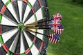 Metal darts have hit the red bullseye on a dart board. Darts Game. Darts arrow in the target center darts in bull`s eye close up. Royalty Free Stock Photo