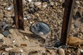 metal detector frame with close-up of the ground, showing broken glass and coins