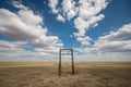 metal detector frame in the middle of an open field, with blue sky and white clouds overhead Royalty Free Stock Photo