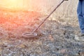 Metal detector. Search for metal artifacts on a field with damaged grass