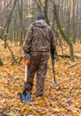 Metal detector at work in the forest. Search for treasure and ancient values. Archeology. Man with a metal detector. Minesweeper .