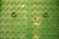 Metal door with a forged pattern and green paint with rings for knocking Royalty Free Stock Photo