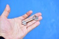 Metal door key in the hands of a man on a blue background Royalty Free Stock Photo