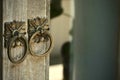 Metal door knob-knocker on the old rustical door. Royalty Free Stock Photo