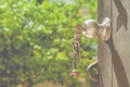 Metal door knob on wooden opened door and keys on the door with green natural background. Royalty Free Stock Photo