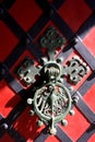 Iron-cast door knocker with eagle on the red door. Royalty Free Stock Photo