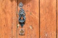 Metal doorknocker on weathered wooden door