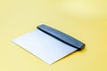 Metal dough scraper knife over bright yellow surface background. Stainless steel flat dough scraper with plastic handle Royalty Free Stock Photo