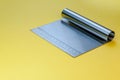 Metal dough scraper knife over bright yellow surface background. Stainless steel flat dough scraper with Ruler scale. Royalty Free Stock Photo