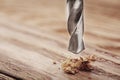 Metal drill bit make holes in a wooden board with expressive texture