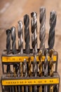 Metal drill bits placed in a stand. Accessories in a home workshop