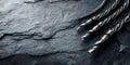 Metal drill bits resting on a textured dark stone surface Royalty Free Stock Photo
