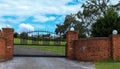 Metal driveway entrance gate set in brick fence Royalty Free Stock Photo