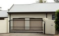 Metal driveway entrance gates set in brick fence