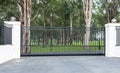 Metal driveway rural property entrance gates set in brick fence with lights and eucalyptus gum trees in background