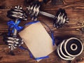 Metal dumbbells and blue ribbon on a wooden background