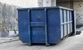 Metal durable blue industrial trash bin for outdoor trash at construction site. Large waste basket for household or industrial