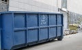 Metal durable blue industrial trash bin for outdoor trash at construction site. Large waste basket for household or industrial