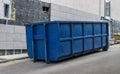 Metal durable blue industrial trash bin for outdoor trash at construction site. Large waste basket for household or industrial