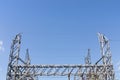 Metal electrical power transfer station trusses centered against a blue sky, creative copy space Royalty Free Stock Photo