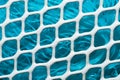 Metal enameled grid. abstract background. blue cloth behind the metallic grate Royalty Free Stock Photo