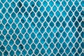 Metal enameled grid. abstract background. blue cloth behind the metallic grate Royalty Free Stock Photo