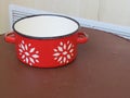 Red enamel pan with white painted flowers