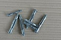 Metal expansion bolt shields or anchor bolts on a gray table.