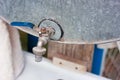 metal faucet with a blue valve, washstand on the street in a country house Royalty Free Stock Photo