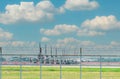 Metal fence of the airport and blur airplane parked at the parking area of the airport. Many planes parked and flights impact by a