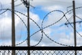 Metal fence with barbed wire against the sky Royalty Free Stock Photo