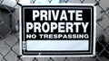 Metal Fence with Black and White Private Property No Trespassing Warning Sign Close Up Royalty Free Stock Photo