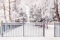 Metal fence with entrance gate along the snow-covered path. Winter Snow urban landscape Royalty Free Stock Photo