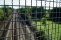 Metal fence with mesh, railroad on background Royalty Free Stock Photo