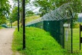 A metal fence of a military object with barbed wire